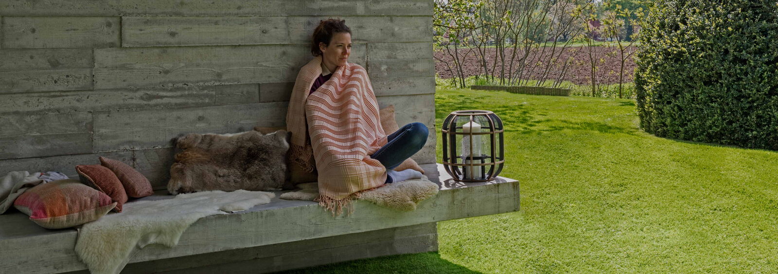 woman sitting on bench in yard with turfgrass